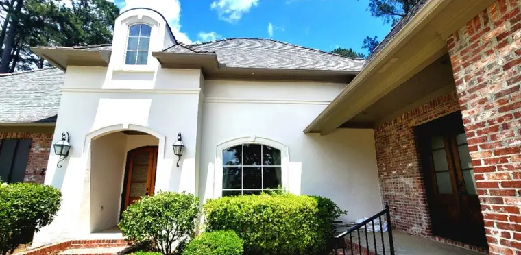 Arched stucco entry beside red brick, after Anthony's crew repainted it