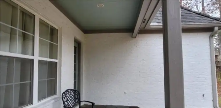 Covered porch with brick painted white and a dark porch ceiling
