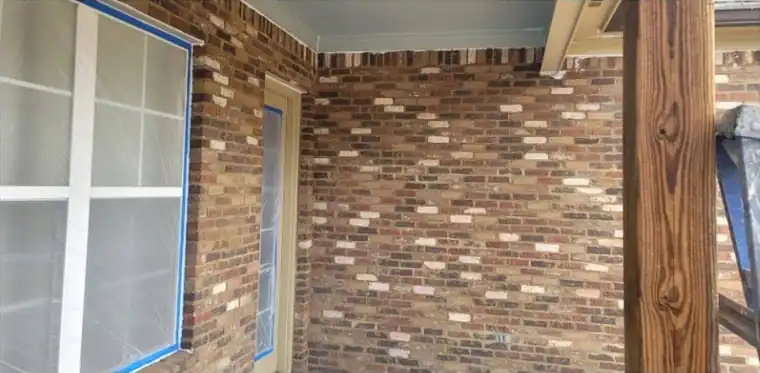 Covered porch with brick and trim painted white, before painting