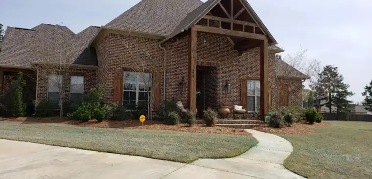 Craftsman entry with painted brick and stained timbers, before painting