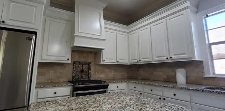 Kitchen with stained cabinets and range hood, after Anthony's crew repainted it