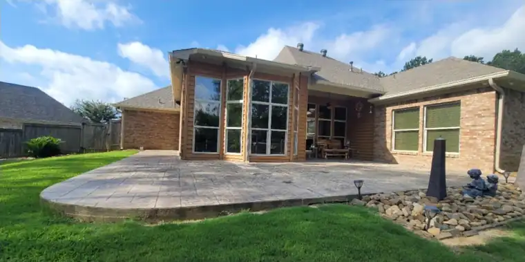 Rear exterior with a stamped patio, tan brick painted white, before painting