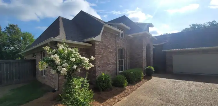 Brick house with a crape myrtle by the drive, before painting