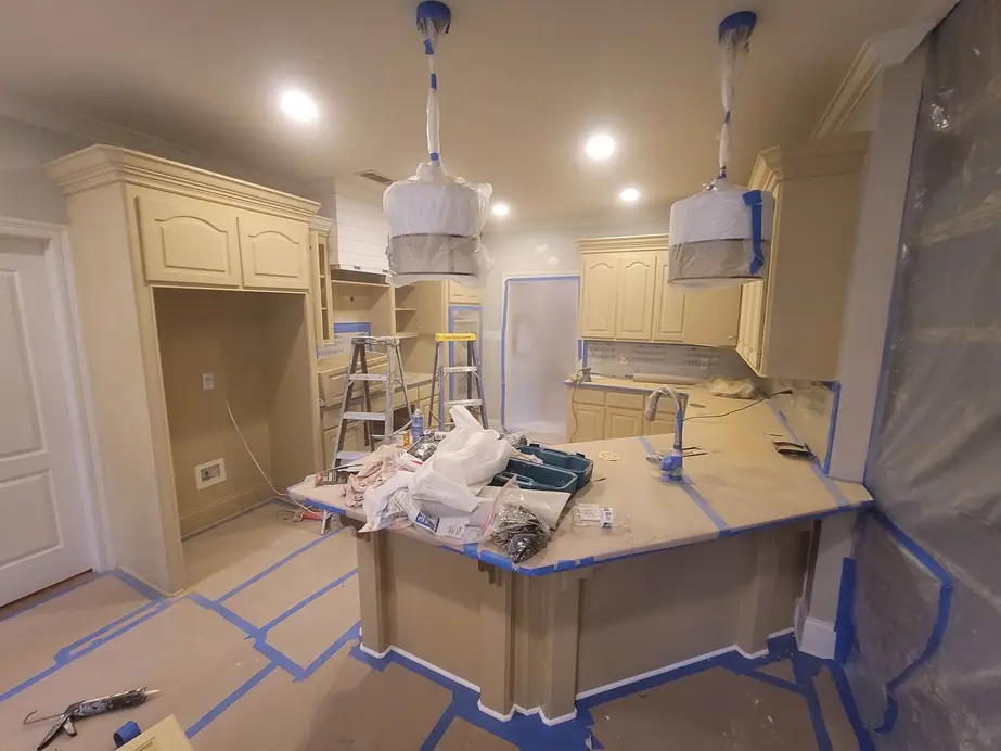 Kitchen mid-job with floors and island masked off and walls prepped for paint